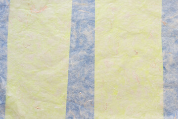 tissue paper background with faint green yellow and blue stripes