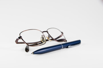 A blue pen is placed next to the glasses on a white background