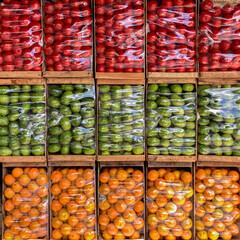 neatly arranged boxes of oranges, tomatoes and zapallitos