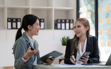 Female business worker with colleagues in Thailand working together at office desk, Female office worker business suit working with document file and paper work.