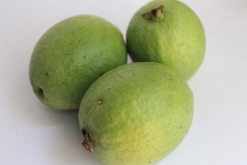 three guavas on a white background