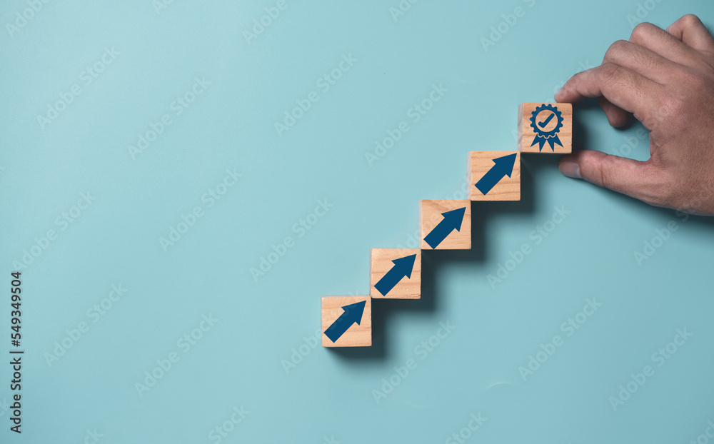 Poster Business hand putting virtual quality assurance and up arrow which print screen on wooden cube for quality enhancement of  guarantee product and ISO service concept.