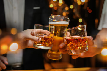 food and drink male friends are happy drinking beer and clinking glasses at a bar or pub.