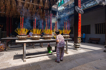 HO CHI MINH CITY, Vietnam - November 08, 2022 - Chua Ba Thien Hau Pagoda in Saigon. Inside Thien Hau Temple, Chinese-style temple of the Chinese sea goddess Mazu. People with burning incense praying.