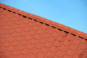 Closeup of house roof top covered with metallic shingles.Tiled covering of building