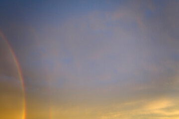 Fototapeta na wymiar Colorful round rainbow against blue evening sky after heavy thunderstorm