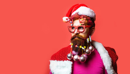 Portrait of a Santa Claus on red background isolated. Christmas people. Bearded modern Santa Claus in Christmas mood