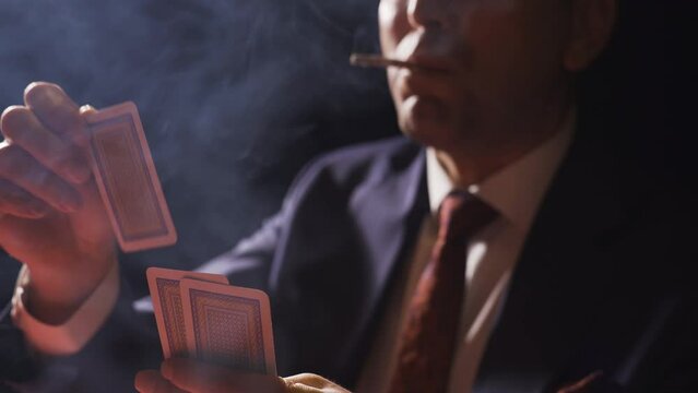 The rich businessman smokes and gambles in the casino.
Cool and strong businessman gambling and smoking a cigarette.
