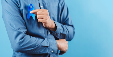 men hands showing Blue ribbon for supporting people living and illness, Colon cancer, Colorectal cancer, Child Abuse awareness, world diabetes day, International Men's Day