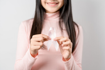 woman hands holding pink ribbon, Breast cancer awareness, world cancer day, national cancer survivor day in february concept...