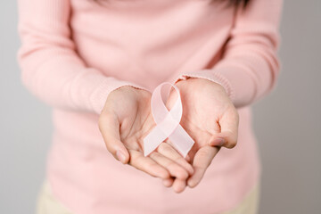woman hands holding pink ribbon, Breast cancer awareness, world cancer day, national cancer survivor day in february concept...