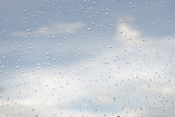 빗방울 맺힌 창 너머로 보이는 맑은 하늘과 구름