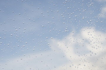 빗방울이 맺힌 창 너머로 보이는 구름과 하늘