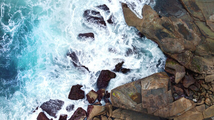 Rock Beach with blue waves aerial drone shot