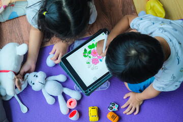 Kindergarten child boy and girl drawing image with tablet