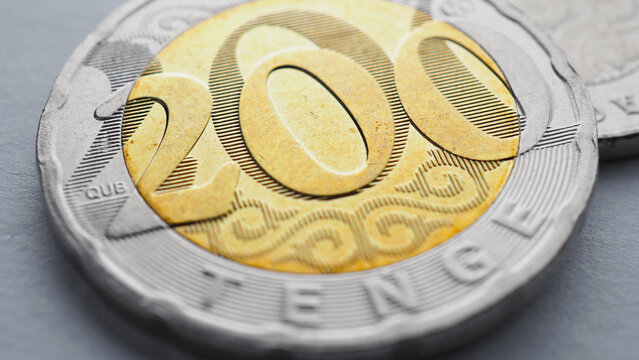 Translation: tenge. Kazakh money lies on light surface. Coin 200 tenge close up. Economy and Central Bank of Kazakhstan. National currency. Credit and loan. Macro