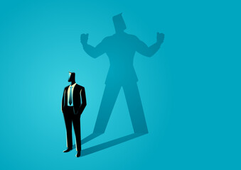 Businessman standing and casting a shadow of a strong superhero