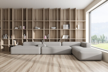 Stylish relaxing interior with couch and wooden shelf, panoramic window