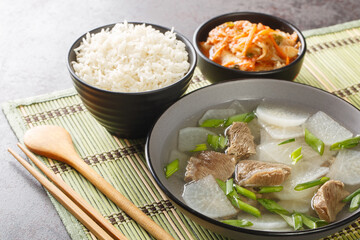 Korean food beef radish soup which is called soegogi muguk served with rice and kimchi closeup on the mat on the table. Horizontal