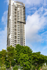 Modern high-rise residential building with a beautiful tropical garden in Singapore. Concept of green environment in the city.