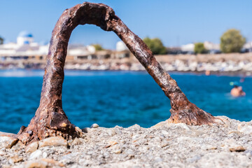 Fototapeta premium Rusty mooring bollard and Santorini beach on the background