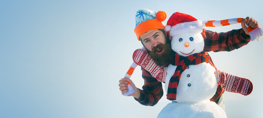 Man with snowman on winter outdoor background. Snow man for winter banner. Christmas and new year snow concept, winter season.