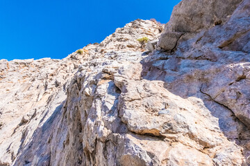 Fototapeta na wymiar Low angle view of a sand stone formation on the Santorini shore