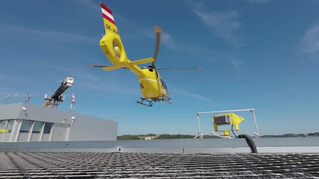 Berlin, Rescue yellow helicopter landing after an accident. Roof of the district hospital clinic. Emergency medical care. Using an ambulance helicopter