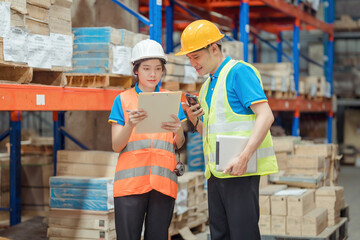 Asian engineer in helmets order and checking goods and supplies on shelves with goods background in warehouse.logistic and business export ,Warehouse worker checking packages on shelf in a large store