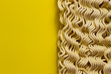 Uncooked instant noodles isolated on yellow background