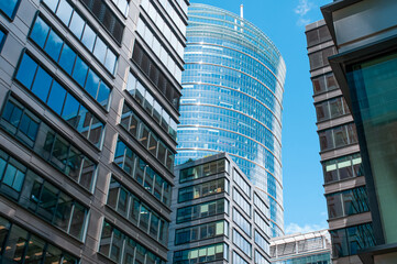 Stylish buildings with many windows under cloudy sky