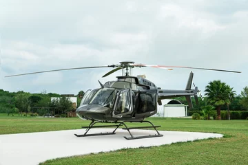 Abwaschbare Fototapete Beautiful modern helicopter on helipad in field © New Africa