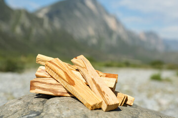 Many palo santo sticks on stone surface in high mountains, closeup