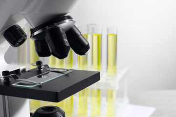 Microscope with drop of urine on glass slide in laboratory, space for text