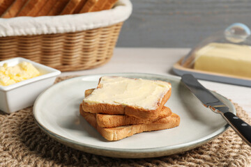 Tasty toasts served with butter on white wooden table