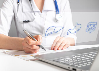 Gastroenterologist doctor works online, sitting at laptop with gastrointestinal results, test,...