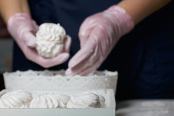 Homemade zephyr. Homemade marshmallows. A woman puts a ready-made zephyr on a tray.