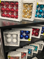 Shelf display of brightly coloured boxed sets of Christmas ornaments 