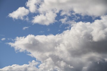 Backdrop of a white cloud in a blue summer sky. Natural background with soft clouds.