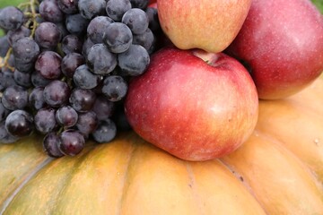 Fototapeta na wymiar Ripe pumpkin, grapes and apples as background, closeup Autumn harvest