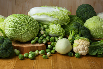 Many different types of fresh cabbage on wooden table