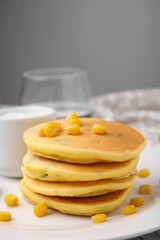 Tasty corn pancakes with sweet kernels served on table, closeup