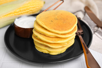 Tasty corn pancakes served on tiled table, closeup