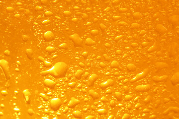 Glass of tasty cold beer with condensation drops as background, closeup