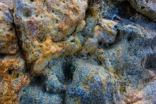 Close up of a sandstone rock with deep holes and ridges