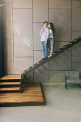 Young couple husband and wife at home sitting on the stairs hugging