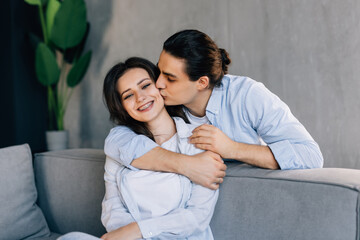 Loving husband comfort upset offended wife, caressing and hugging her from behind.