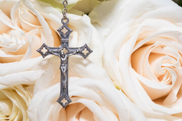 Metal cross and roses, flowers on table