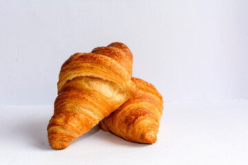 Two crispy french butter croissants on the white background.