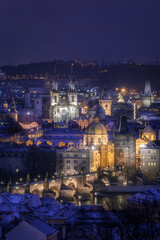 View of the centre of Prague and Charles Bridge, Old town Square and Tyn temple in the evening with night illumination in winter. Tourism. Towers of Prague. Czech Republic. Snow.	
